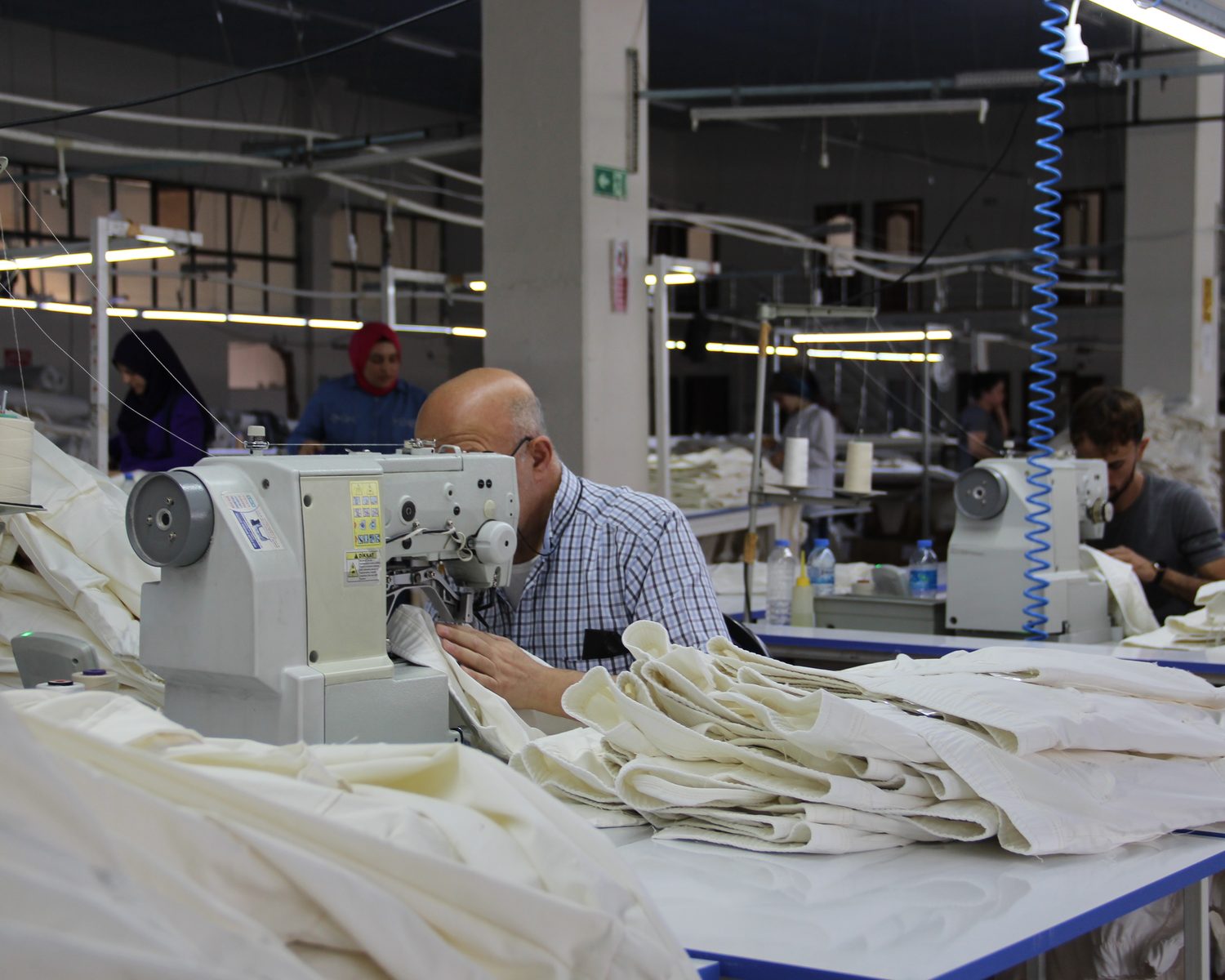 CRISTAL7 sewing line — denim being assembled by hand